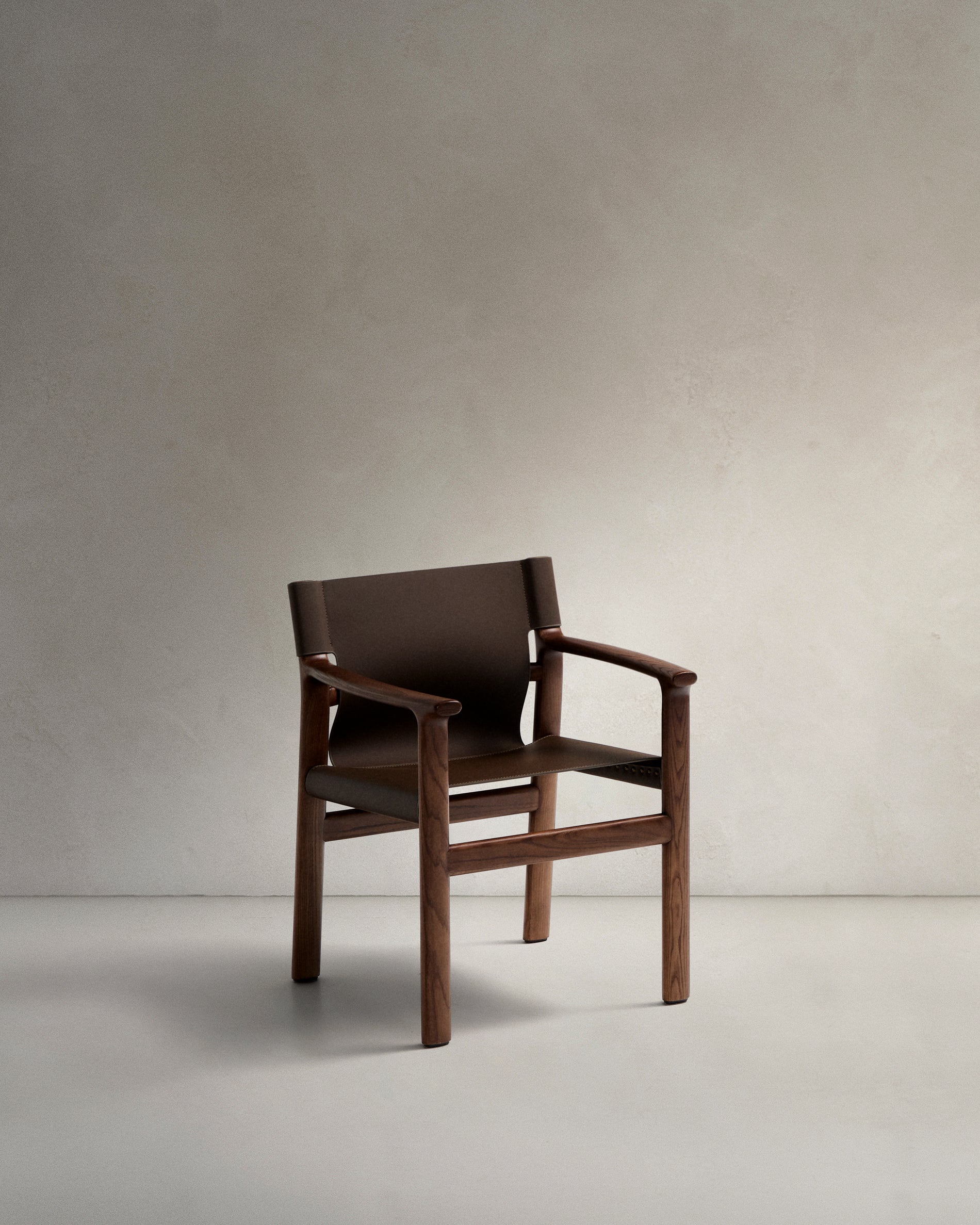 Jan chair made of dark brown recycled leather fibres and FSC 100% solid ash wood with walnut-coloured finish