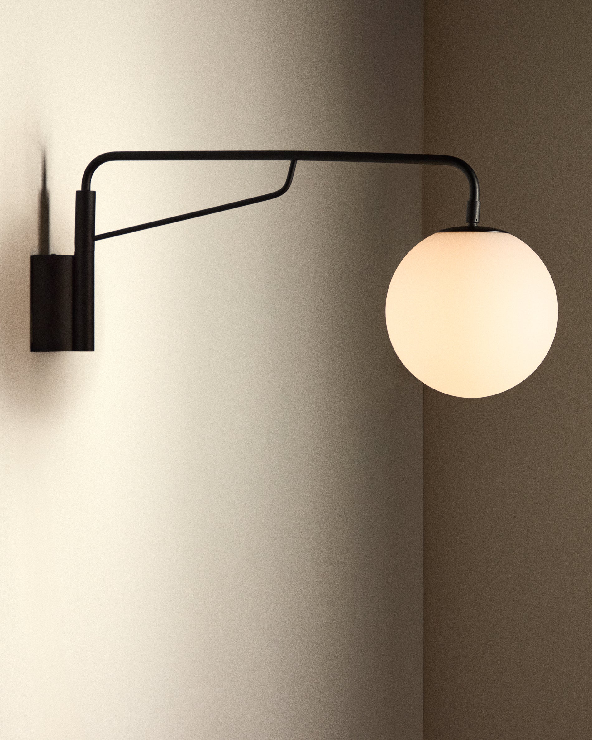 Eilo wall light in black steel with frosted glass globe