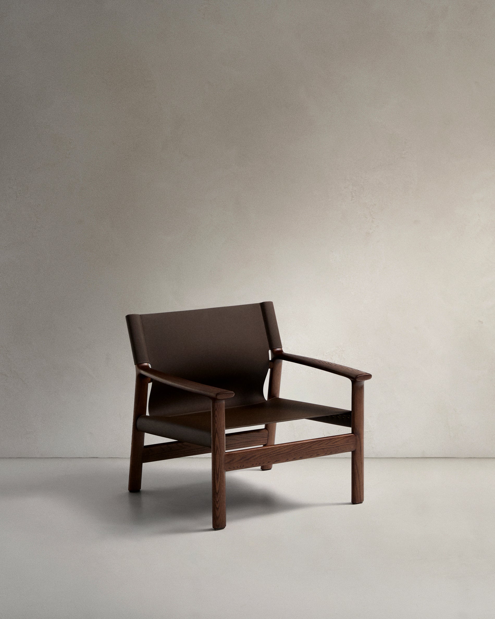 Jan armchair made of dark brown recycled leather fibres and FSC 100% solid ash wood with walnut-coloured finish